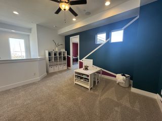 A chic playroom with a modern design, featuring a geometric accent wall, cozy carpet, and ample natural light.