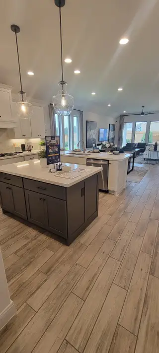 A spacious kitchen with contrasting islands, pendant lighting, and ample storage, perfect for culinary enthusiasts and gatherings.
