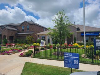 A charming brick home with vibrant landscaping in Riverfield by D.R. Horton (Josephine, TX).