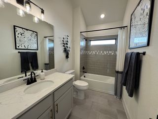 A modern bathroom with a white vanity, subway tile bathtub, and black hardware, giving a sleek, contemporary look.