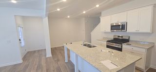 A sleek kitchen with white cabinetry, stainless steel appliances, and a spacious island with granite countertops in Bethlehem, GA.