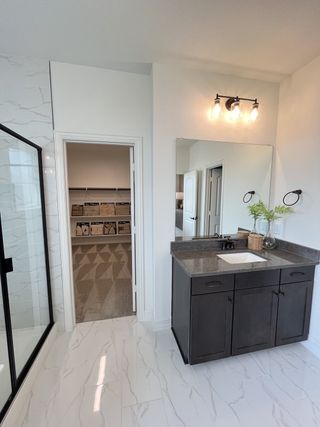 Elegant bathroom with a sleek dark vanity, large mirror, and marble-style flooring.