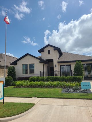 Street view A charming brick home with lush landscaping in Caldwell Lakes by K. Hovnanian® Homes, Dallas, TX.