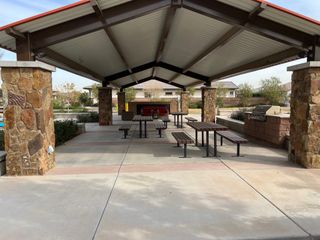 A charming covered pavilion with picnic tables and a grill in Sierra at Alamar by David Weekley Homes (Avondale, AZ).