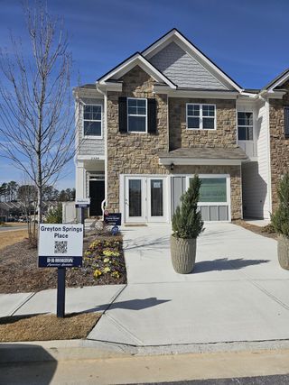A charming stone-front home with modern siding in Towns at Ivy Creek by Lennar, Buford, GA.