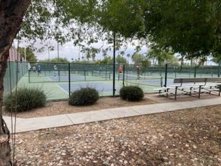Tennis courts surrounded by lush greenery in Robson Ranch Arizona by Robson Resort Communities (Eloy, AZ).