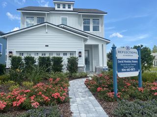 A beautiful white home with lush landscaping in Reflections 50' Front Load by David Weekley Homes, Ponte Vedra Beach, FL.