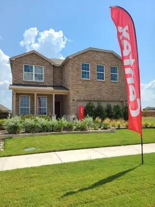 Model Home A beautiful brick home with lush landscaping in Ashford Crossing by Centex, Princeton, TX, featuring a welcoming front porch.