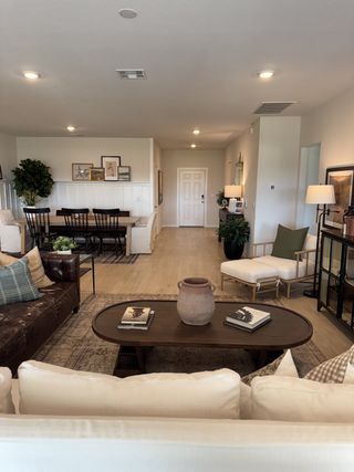 An elegant living-dining area with warm wood floors, cozy seating, and tasteful art. Perfect for gatherings and relaxation.