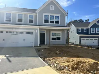 A modern gray two-story home with a spacious garage in Highland Ridge by Ryan Homes (Willow Spring, NC).