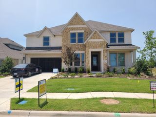 A charming stone and brick home with manicured landscaping in Stone River Glen 60s by Bloomfield Homes (Royse City, TX).