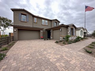 A modern stone-accented home with a spacious driveway in Parkside Almeria Collection by Taylor Morrison, Avondale, AZ.