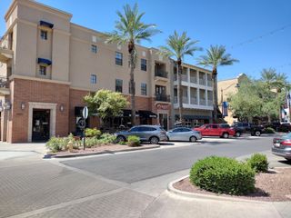 Model Home A charming street view with palm trees and shops in Heritage at Verrado by Richmond American Homes (Buckeye, AZ).