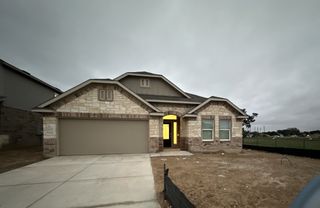 A beautifully crafted stone and brick home with a welcoming entryway in Waterwheel by Lennar (San Antonio, TX).