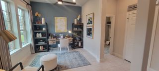 Model Home A chic home office with a blue accent wall, built-in bookshelves, and contemporary decor, creating a functional yet stylish workspace.