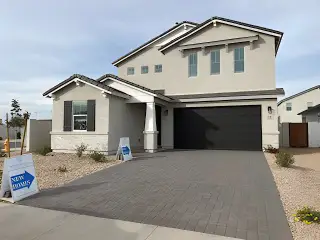 Street view A modern two-story home with a sleek façade and spacious driveway in Pecan Cove by Newport Homes (San Tan Valley, AZ).