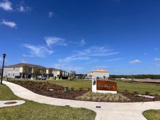 Modern townhomes with landscaped paths under a bright blue sky in Westview: Overlook Townhomes by Lennar (Kissimmee, FL).