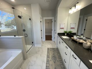 A modern bathroom featuring a glass shower, sleek black countertop, and elegant white cabinetry.