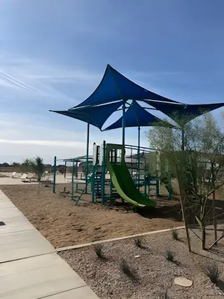 Community Amenities A spacious playground with shade for children in Wildera – Canyon Series by Landsea Homes, San Tan Valley, AZ.