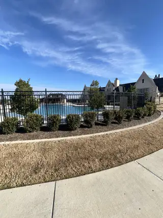 Community Amenities A beautifully landscaped outdoor pool area with a view of the luxurious Cambridge Crossing clubhouse.