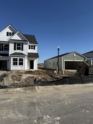 A modern white home under construction in Lindera Preserve at Cane Bay Plantation: Arbor Collection by Lennar (Summerville, SC).