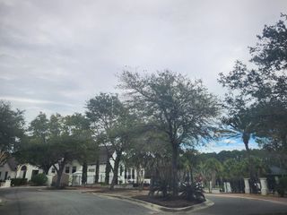 A picturesque community entrance with mature trees and a gated entry in Amelia National Country Club by Riverside Homes (Fernandina Beach, FL).