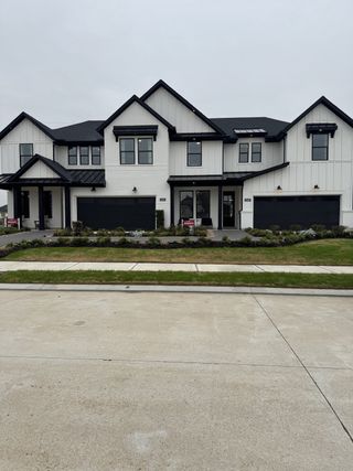 A modern white home with black accents and lush landscaping in Jordan Ranch by Beazer Homes (Katy, TX).