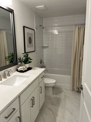 A chic bathroom featuring white cabinetry, a sleek sink, and elegant tiling with contemporary decor and lighting.
