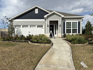 Street view A charming home with landscaped garden and welcoming pathway in Park Vista at El Tesoro by LGI Homes (Houston, TX).