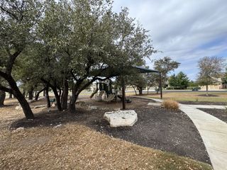 Community Amenities A scenic park with mature trees and a winding pathway provides a peaceful setting in Lakeside at Lake Georgetown by Coventry Homes (Georgetown, TX).