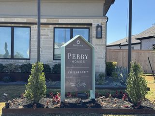 Charming stone façade with lush landscaping at Nolina 60' by Perry Homes in Georgetown, TX.