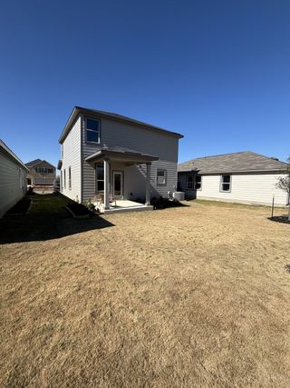 A charming gray two-story home with a spacious backyard in Spanish Trails Villas by KB Home (San Antonio, TX).