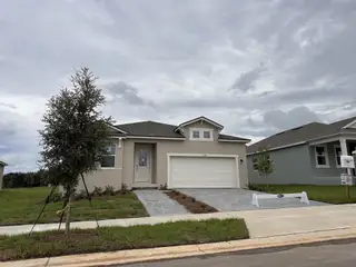 A contemporary home with a gray facade and landscaped yard in Rainwood by Mattamy Homes (Clermont, FL).