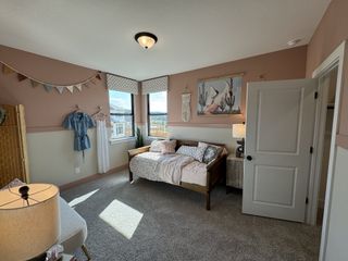 A cozy bedroom with soft pink walls, a daybed, and charming decor, offering a warm and inviting atmosphere.
