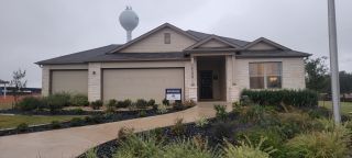 Street view A charming stone exterior home with lush landscaping in Summer Hills by M/I Homes (San Antonio, TX).