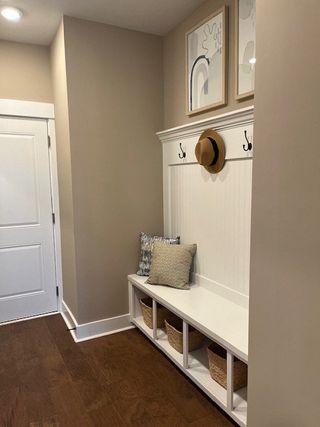 A cozy entryway with a built-in bench, storage cubbies, hooks, and decorative artwork on the wall.