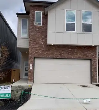 Street view A contemporary brick-accented home with a sleek facade in Rose Hill by Chesmar Homes (San Antonio, TX).