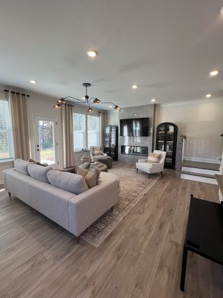 A modern living room with sleek hardwood floors, cozy gray seating, and a stylish fireplace.
