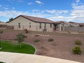 A charming beige home with a tiled roof and desert landscaping in Arroyo Vista II by KB Home (Casa Grande, AZ).