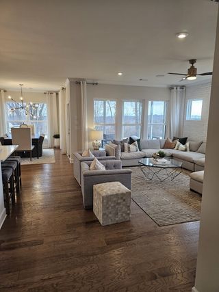 An elegant open-concept living room featuring a cozy sectional, modern decor, and large windows for abundant natural light.