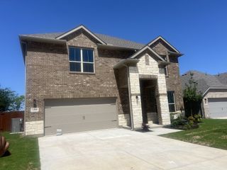 Street view A beautiful brick home with a stone accent façade in Parkerville Meadows by D.R. Horton, located in DeSoto, TX.