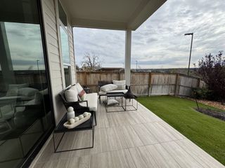 Model Home A cozy patio with plush seating, elegant decor, and a fenced backyard view, perfect for relaxing afternoons.