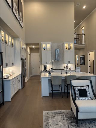 A chef’s dream kitchen with soaring ceilings, white cabinetry, quartz countertops, and high-end appliances for effortless entertaining.