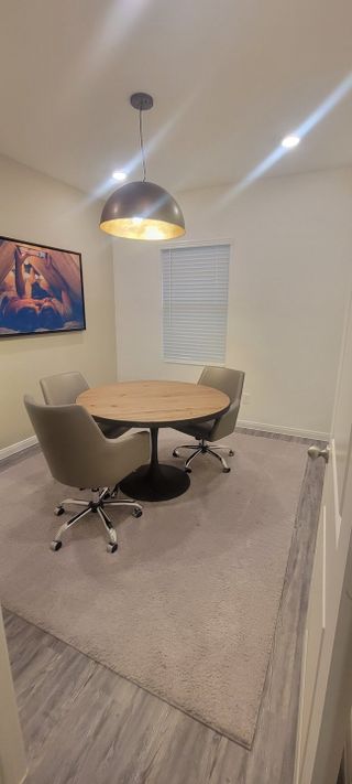 Model Home A cozy dining nook with a round table, gray chairs, stylish pendant light, and modern artwork.
