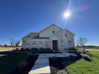 A charming brick home with a manicured lawn in Calumet by Brightland Homes (Jarrell, TX).