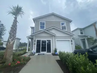 A modern gray home with manicured landscaping at Irongate Villas by D.R. Horton, Jacksonville, FL.