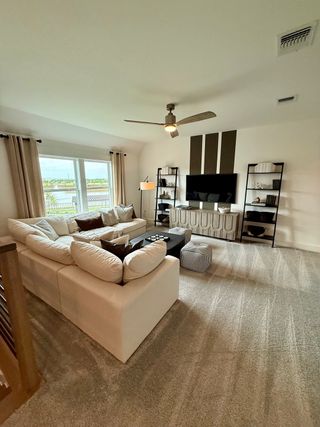 A cozy living room with a plush sectional sofa, modern media setup, and elegant shelving units.