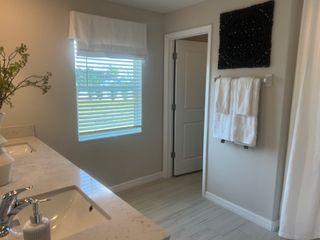 A bright bathroom with dual sinks, elegant marble counters, and modern decor.