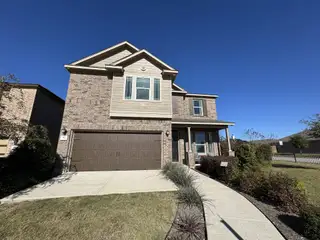 A charming two-story brick home with lush landscaping in Sonterra - Cool Water by KB Home (Jarrell, TX).