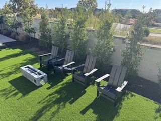 Model Home A stylish covered patio with comfortable outdoor seating, overlooking a scenic backyard.